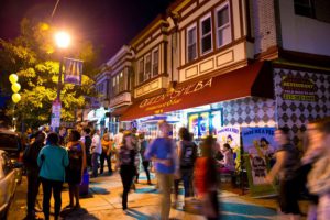 A color photograph of people walking past the Queen of Sheba restaurant on Baltimore Avenue