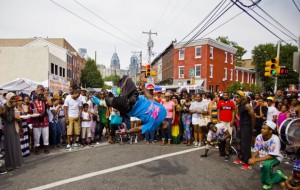 A street-corner dancer goes airborne to the delight of festivalgoers during the annual ODUNDE festival.
