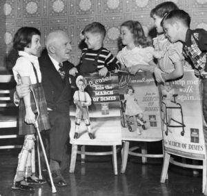 a black and white photograph of five polio stricken children holding March of Dimes posters with Philadelphia March of Dimes leader