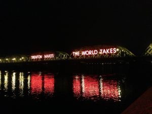 Photograph of the Lower Trenton Bridge. The slogan Trenton Makes, the World Wakes is illuminated on the side.